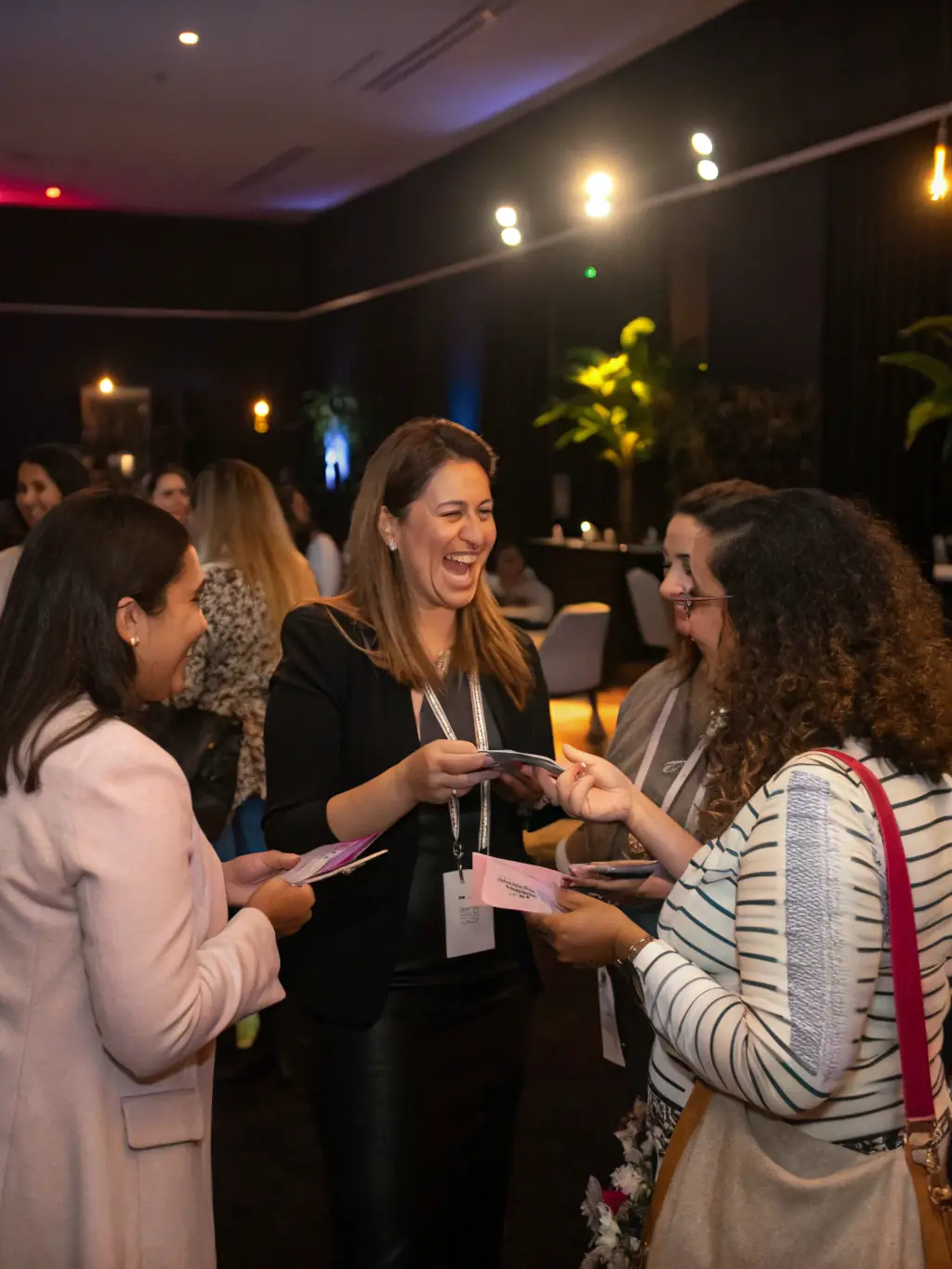 A vibrant image of women entrepreneurs networking at an Aseme Canarias event, with attendees exchanging business cards and engaging in lively conversations against the backdrop of a Canary Islands sunset.